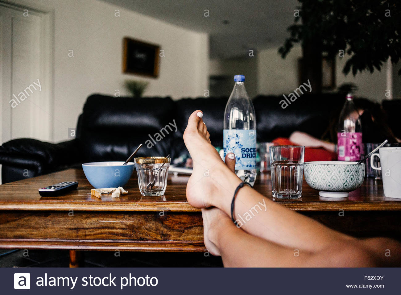 Low Section Of Woman With Feet Up On Coffee Table At Home Stock regarding sizing 1300 X 956
